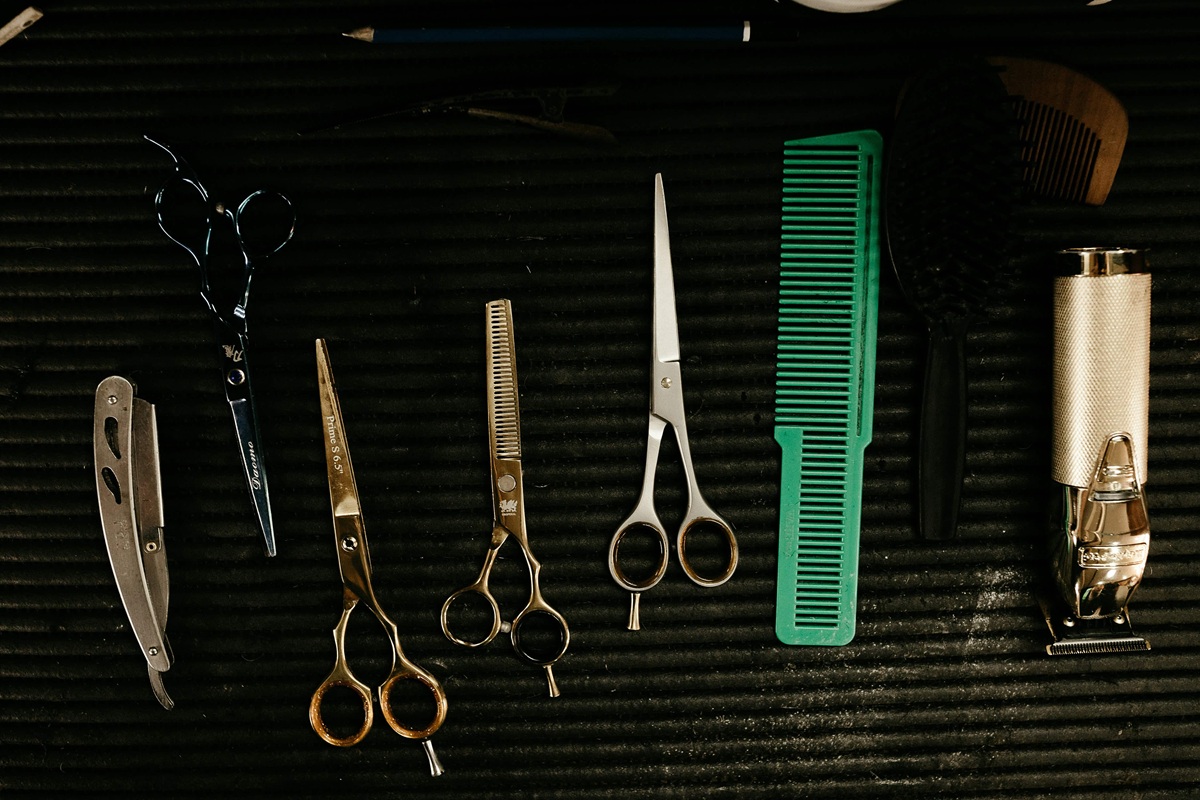 Salon tools including scissors, combs, and clippers laid out at a backbar